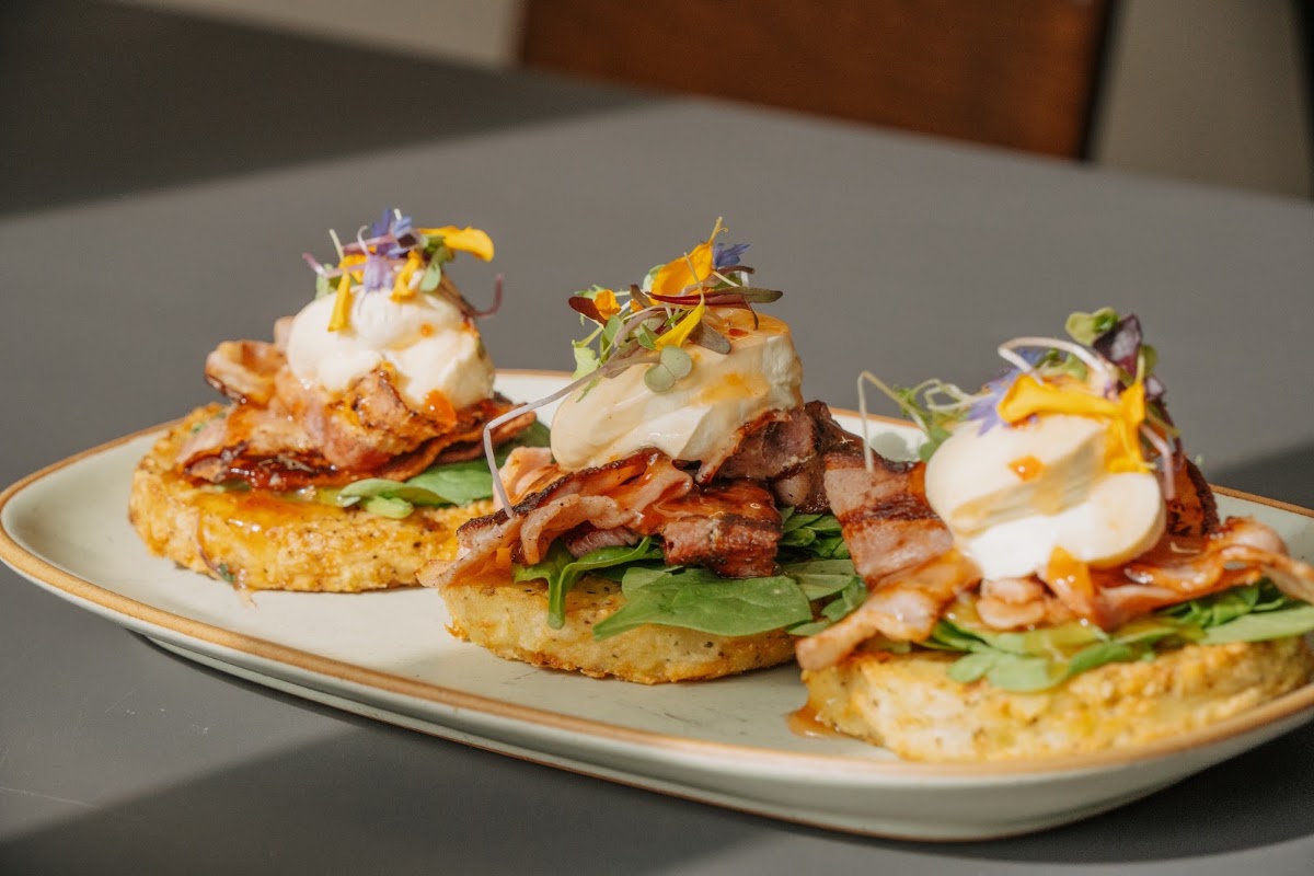Bacon, poached egg and rosti stacks with edible flowers